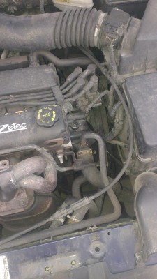 Černá plastová součástka hned napravo od motoru - zpod ní to kape